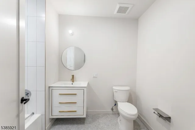 a bathroom with a sink toilet and a mirror