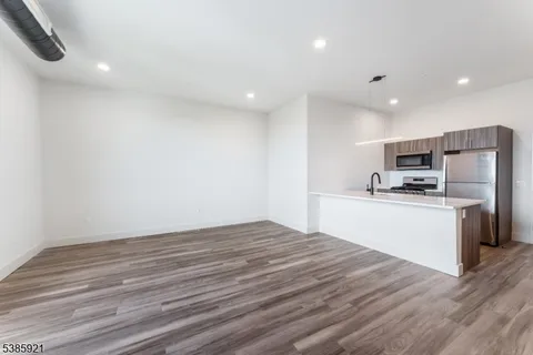 a kitchen with granite countertop stainless steel appliances a refrigerator sink and microwave