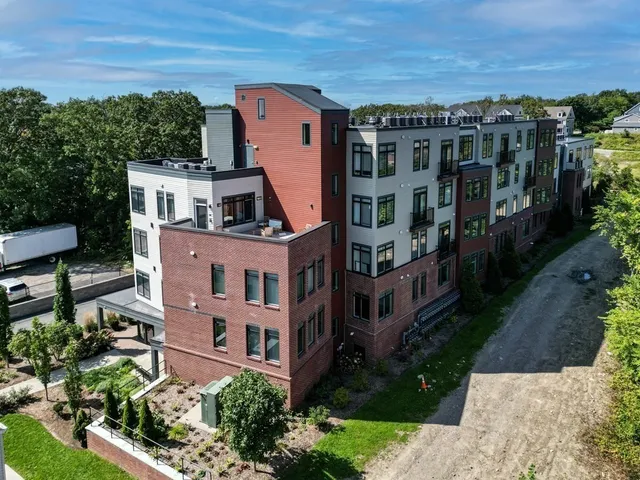 an aerial view of multiple houses with a yard