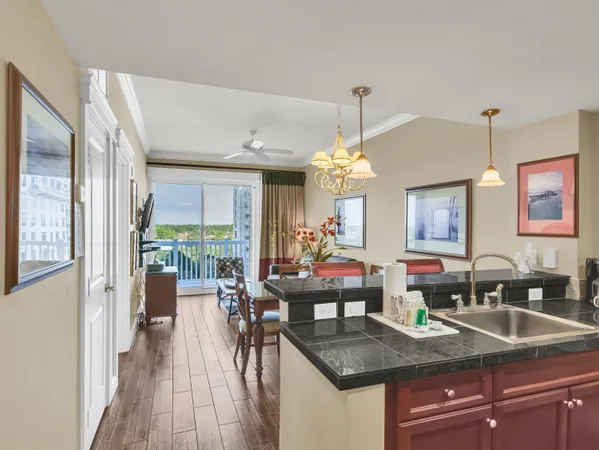 a view of a kitchen counter top space a sink wooden floor and a chandelier