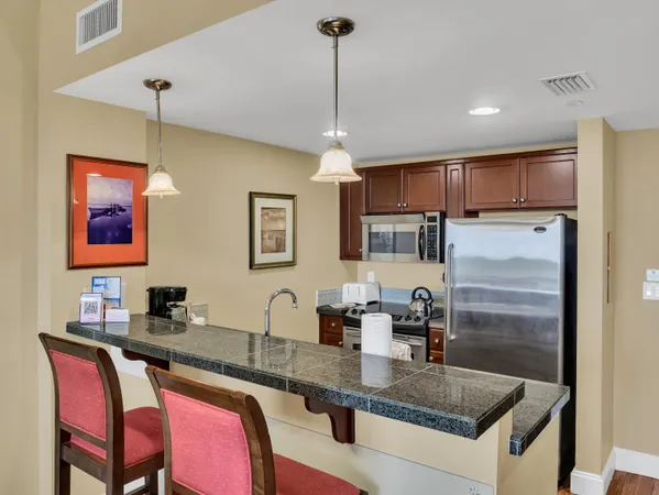 a view of a dining room and livingroom with furniture wooden floor a chandelier