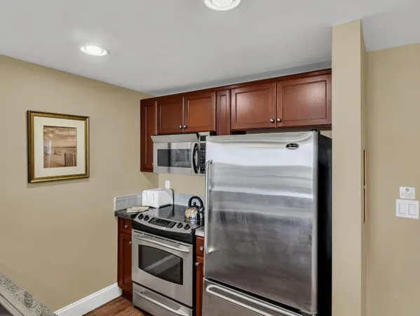 a kitchen with stainless steel appliances granite countertop a sink refrigerator and cabinets