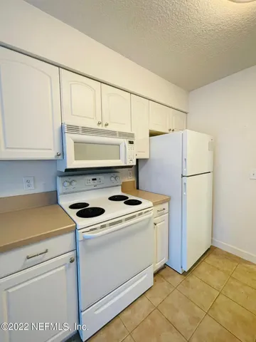 a kitchen with a stove a refrigerator and a sink