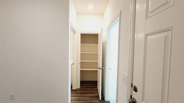 a view of a hallway with wooden floor and closet