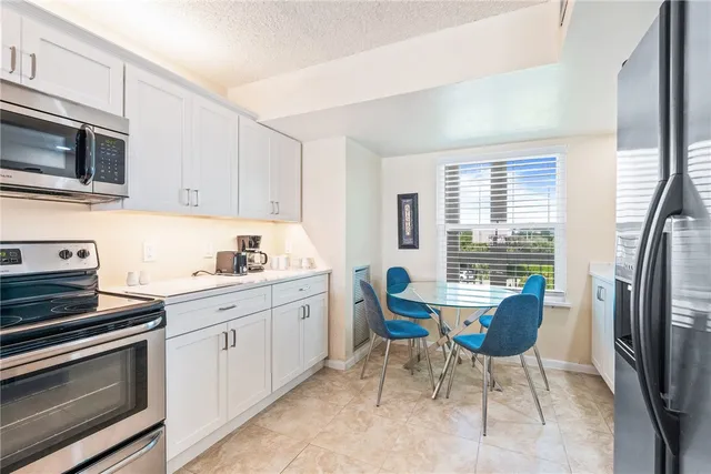 a kitchen with stainless steel appliances a stove a sink cabinets and a refrigerator