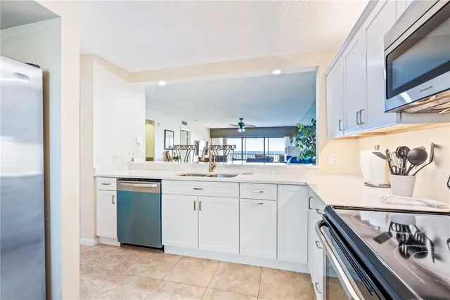 a kitchen with granite countertop white cabinets sink and stainless steel appliances