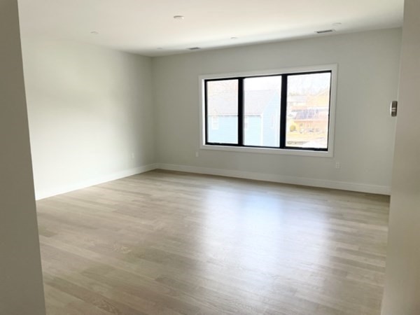 21 Tocci Path Newton, MA 02459 - Photo 15 of 24 an empty room with wooden floor and windows