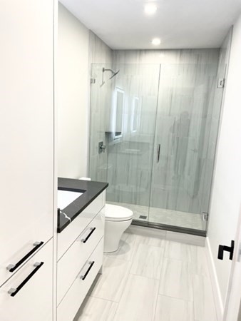 21 Tocci Path Newton, MA 02459 - Photo 24 of 24 a bathroom with a granite countertop sink a toilet and shower