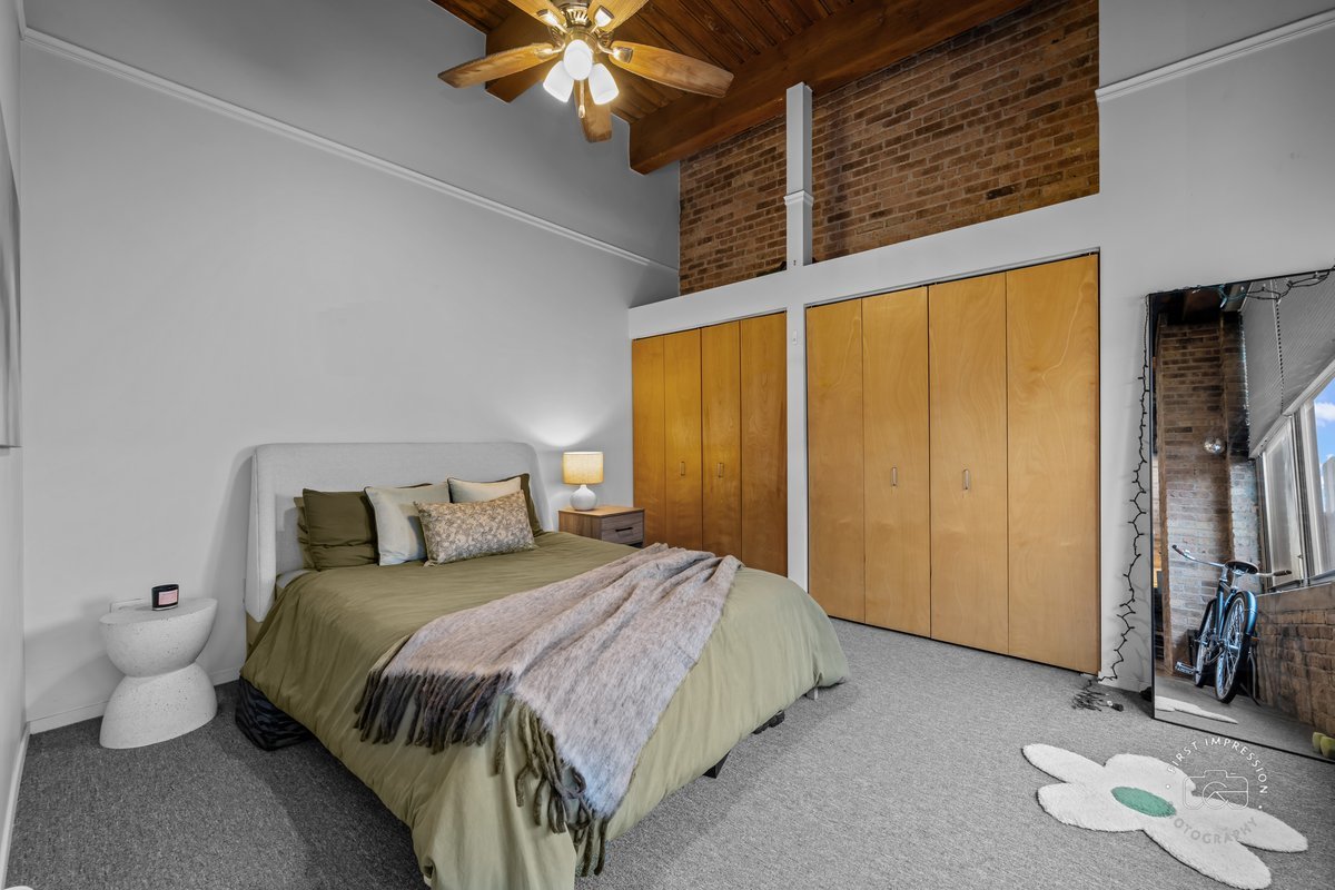 1500 West Monroe Street, Unit 409 Chicago, IL 60607 - Photo 13 of 20 a bedroom with a bed and a chandelier