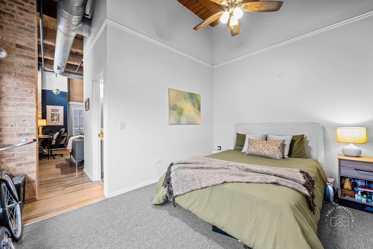 1500 West Monroe Street, Unit 409 Chicago, IL 60607 - Photo 14 of 20 a bedroom with a bed and a chandelier