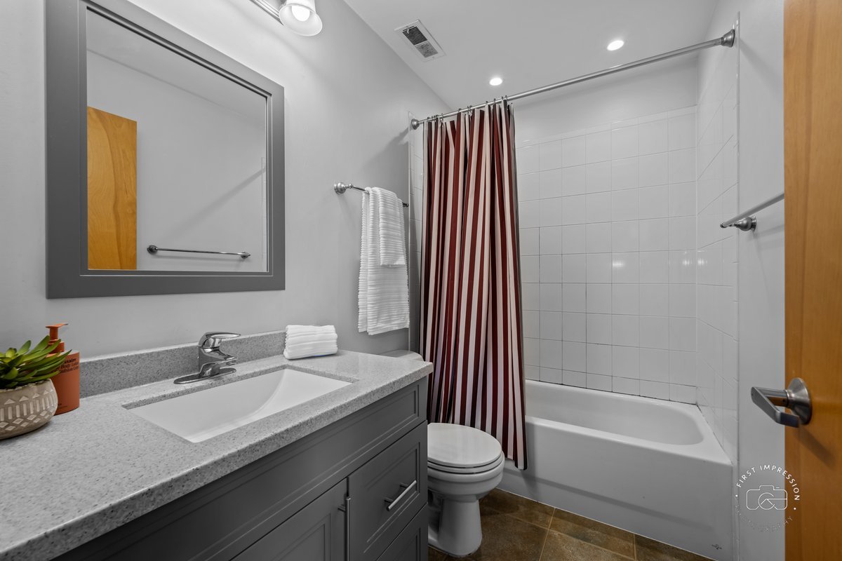 1500 West Monroe Street, Unit 409 Chicago, IL 60607 - Photo 16 of 20 a bathroom with a granite countertop sink toilet and shower