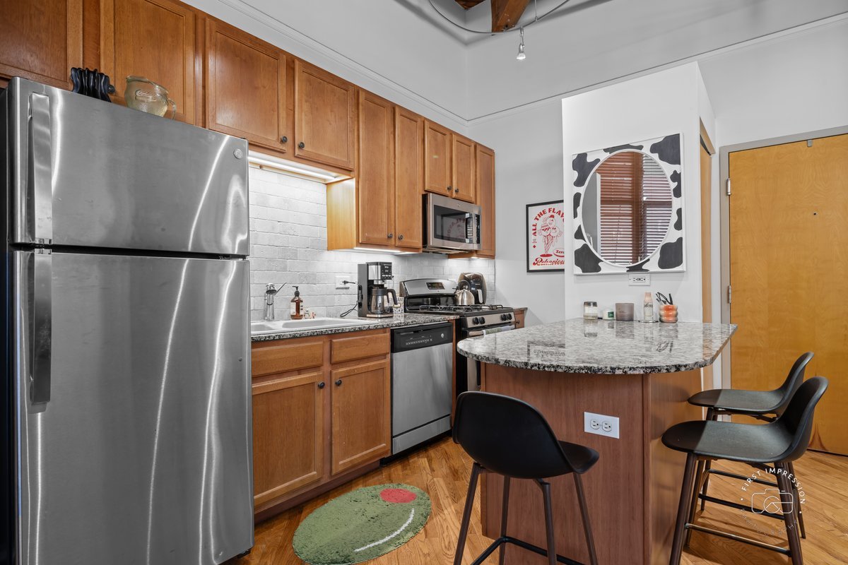 1500 West Monroe Street, Unit 409 Chicago, IL 60607 - Photo 7 of 20 a kitchen with stainless steel appliances granite countertop a refrigerator and a stove top oven