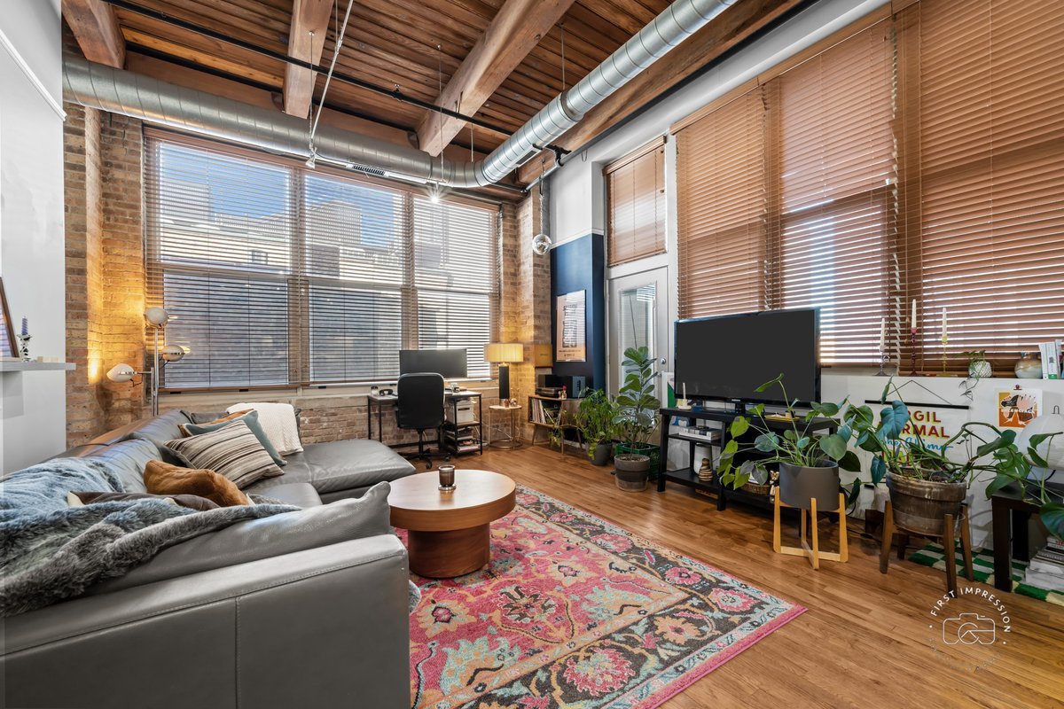 1500 West Monroe Street, Unit 409 Chicago, IL 60607 - Photo 8 of 20 a living room with furniture a flat screen tv and a large window