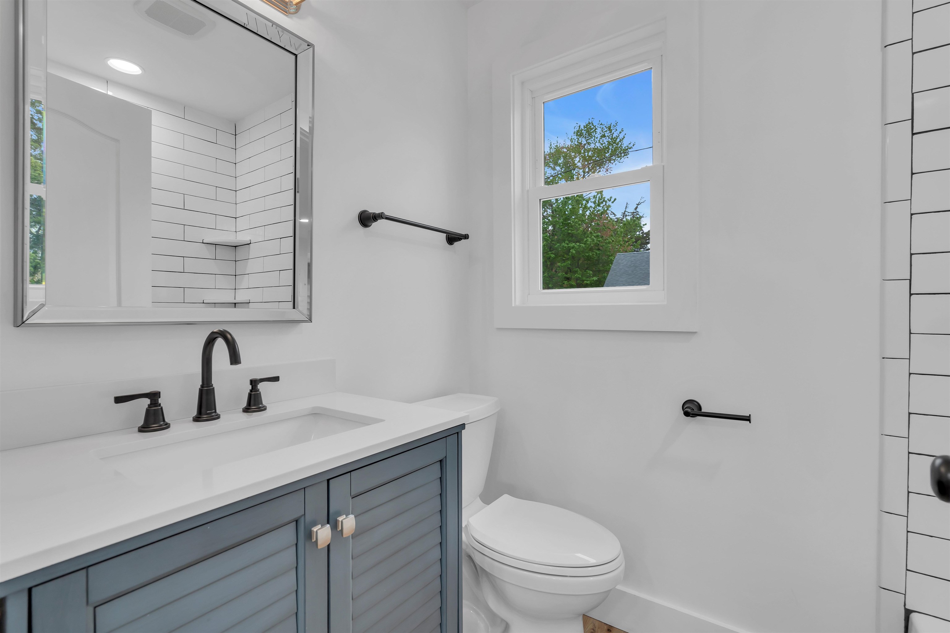 539 Seashore Road Erma, NJ 08204 - Photo 13 of 18 a bathroom with a sink a mirror a toilet and a window