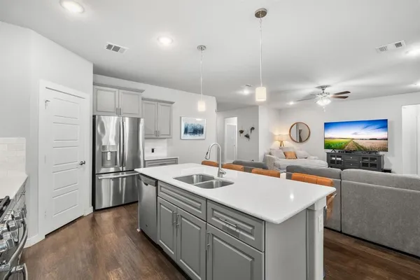 a kitchen that has a sink a stove and chairs