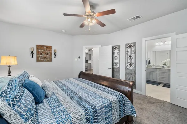 a bedroom with a large bed and a chandelier