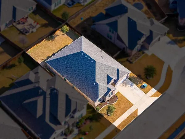 a roof deck with table and chairs with wooden floor