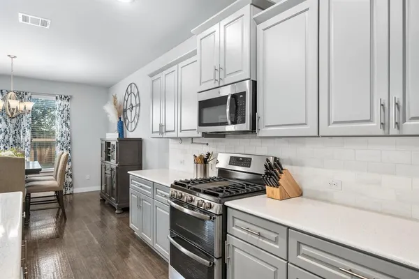 a kitchen with stainless steel appliances granite countertop a stove a microwave and a refrigerator