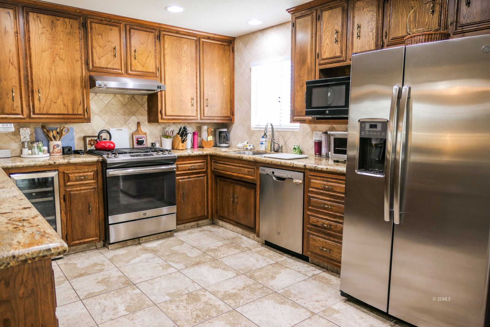 308 South Lilac Street Ridgecrest, CA 93555 - Photo 12 of 50 a kitchen with stainless steel appliances granite countertop a stove a sink dishwasher and a refrigerator