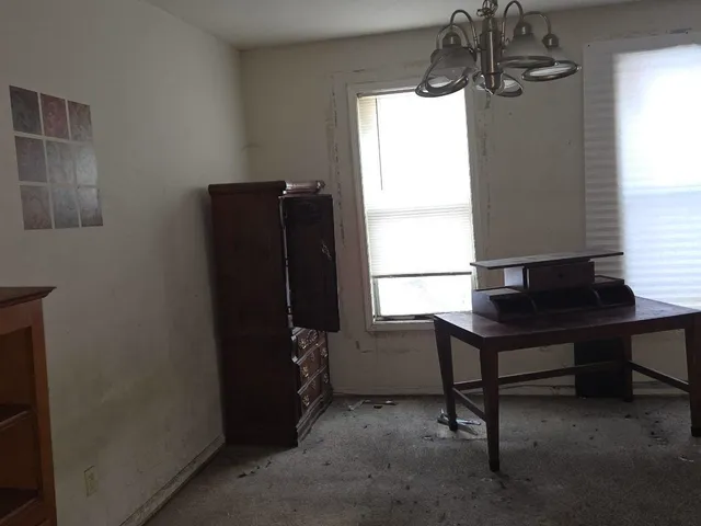 a view of a workspace with furniture and a window