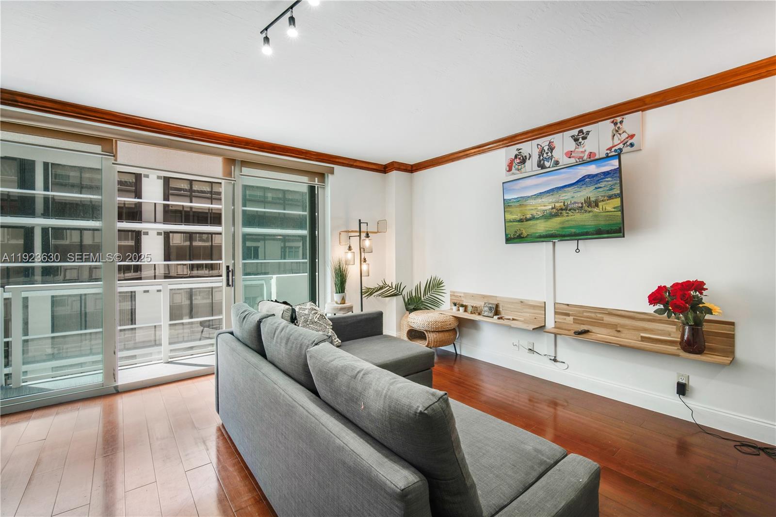 9499 Collins Avenue, Unit 1005 Surfside, FL 33154 - Photo 12 of 35 a living room with furniture and a flat screen tv