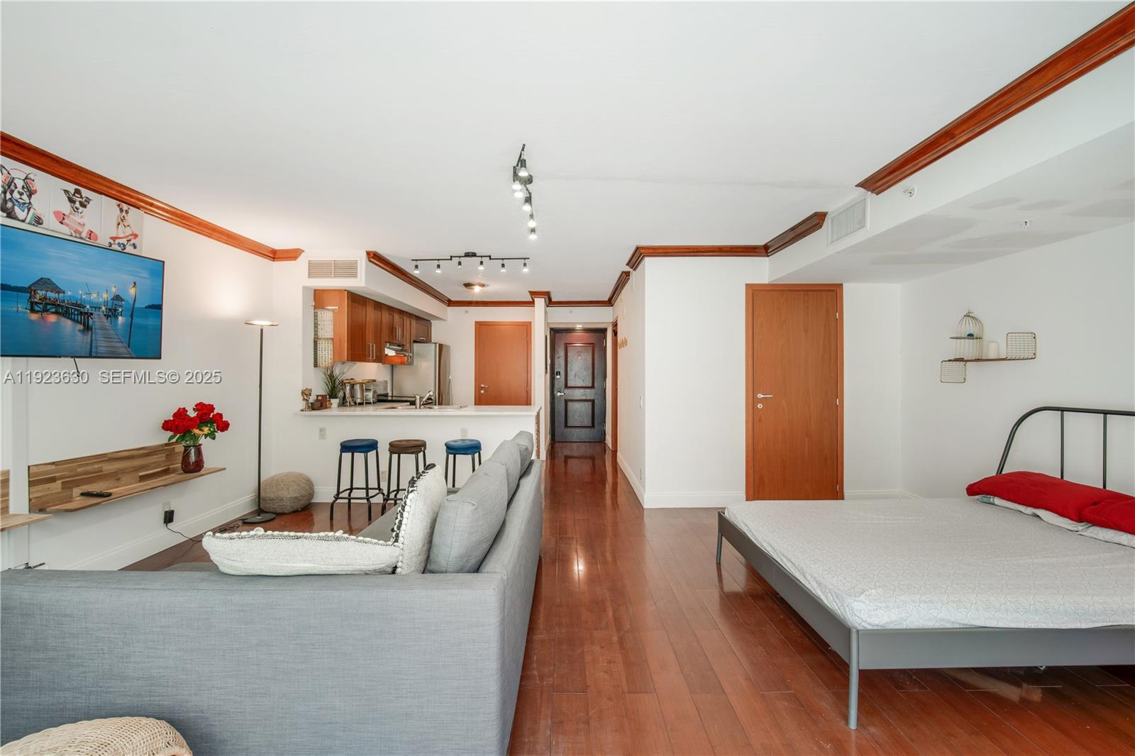 9499 Collins Avenue, Unit 1005 Surfside, FL 33154 - Photo 16 of 35 a living room with furniture and flat screen tv