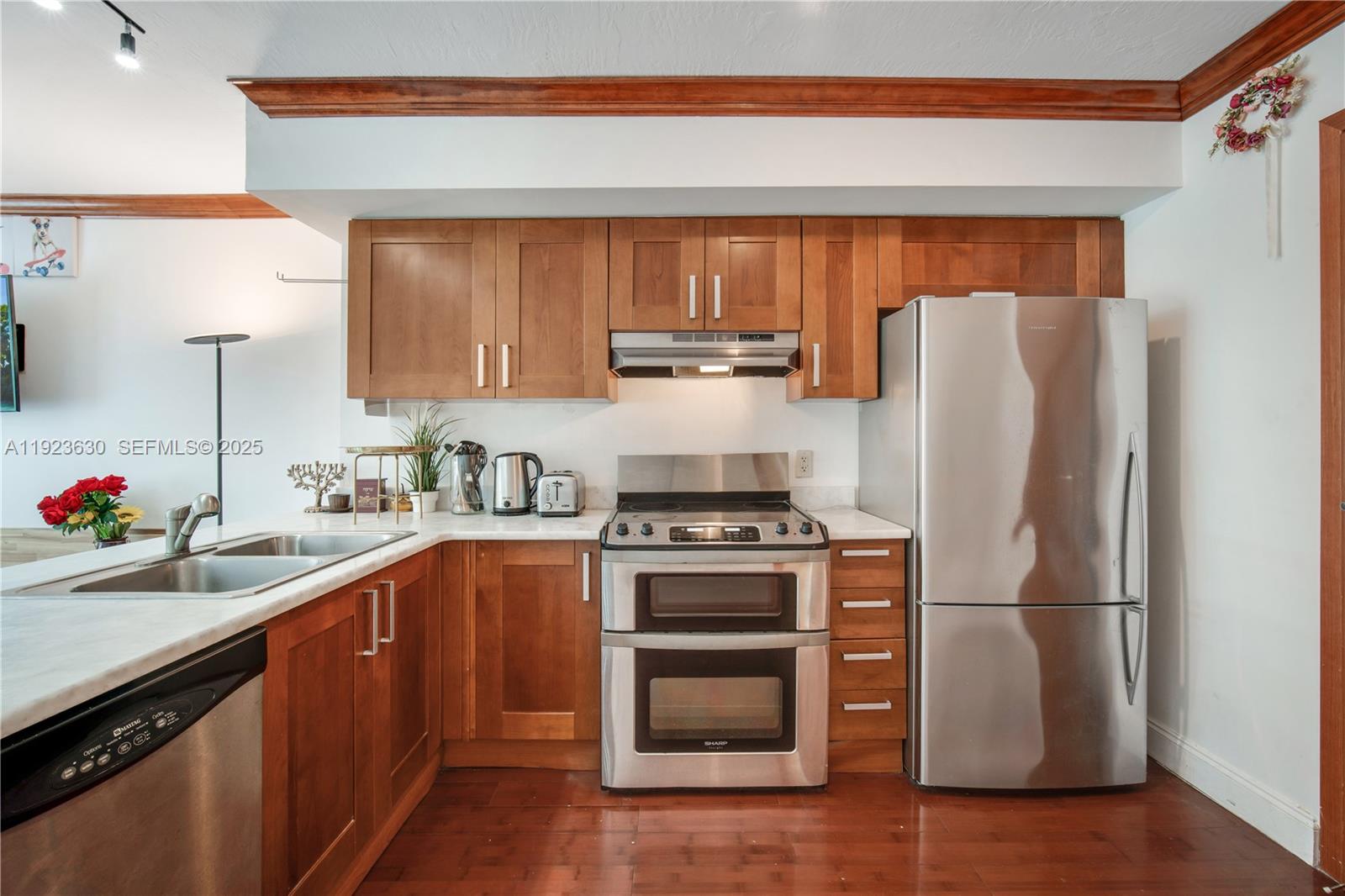 9499 Collins Avenue, Unit 1005 Surfside, FL 33154 - Photo 4 of 35 a kitchen with a refrigerator sink and cabinets