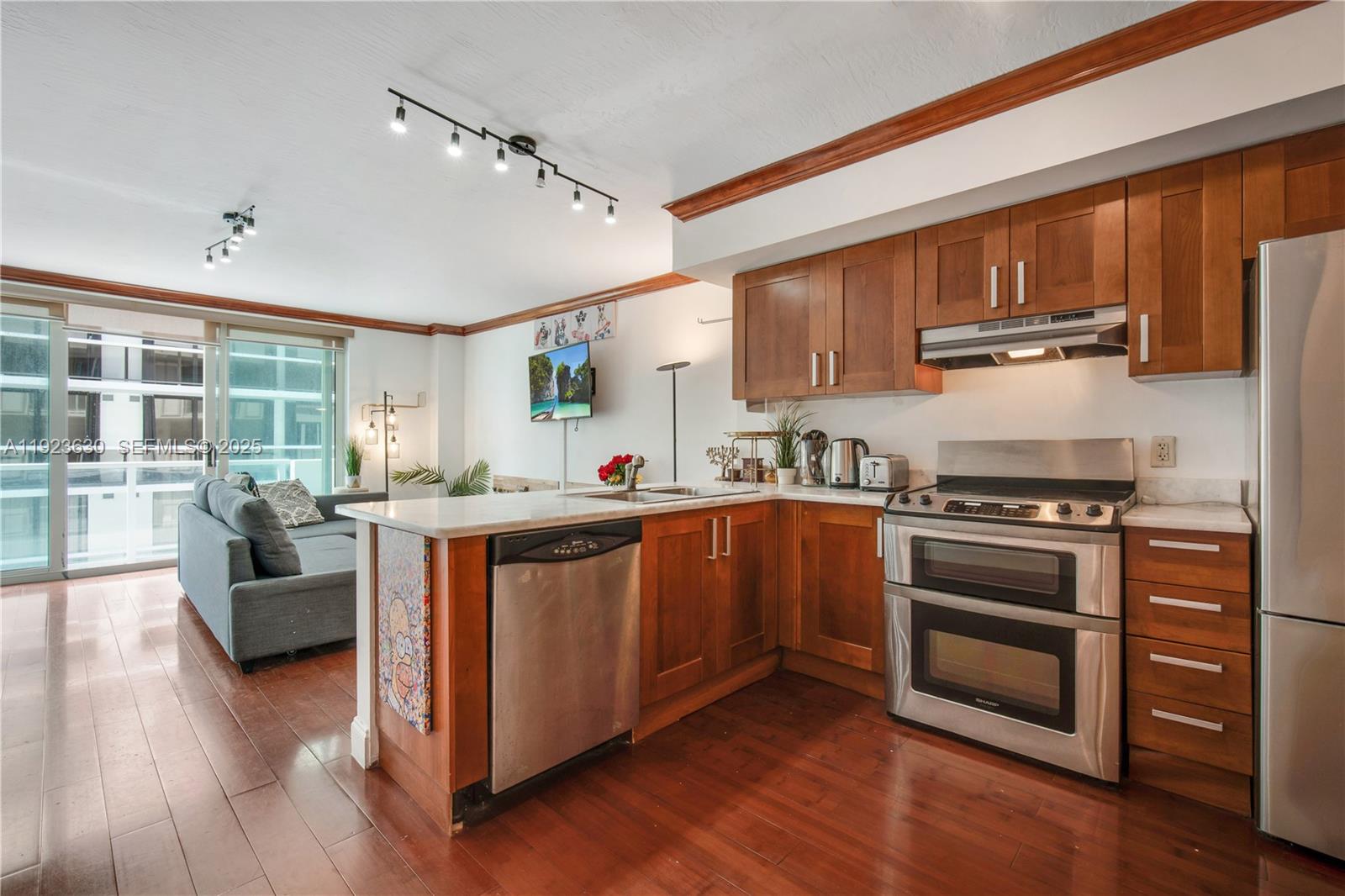 9499 Collins Avenue, Unit 1005 Surfside, FL 33154 - Photo 5 of 35 a kitchen with stainless steel appliances granite countertop a stove and a refrigerator