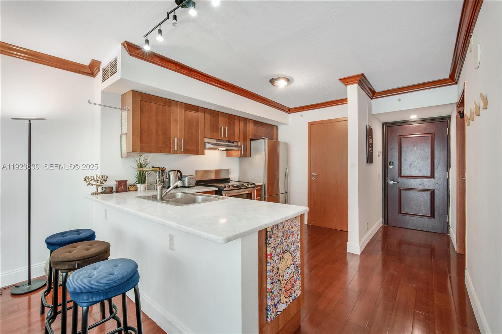 9499 Collins Avenue, Unit 1005 Surfside, FL 33154 - Photo 7 of 35 a kitchen with sink cabinets and wooden floor