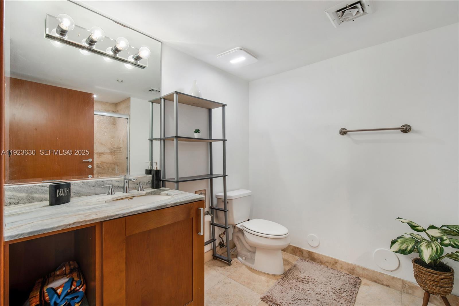 9499 Collins Avenue, Unit 1005 Surfside, FL 33154 - Photo 9 of 35 a bathroom with a granite countertop sink toilet and shower