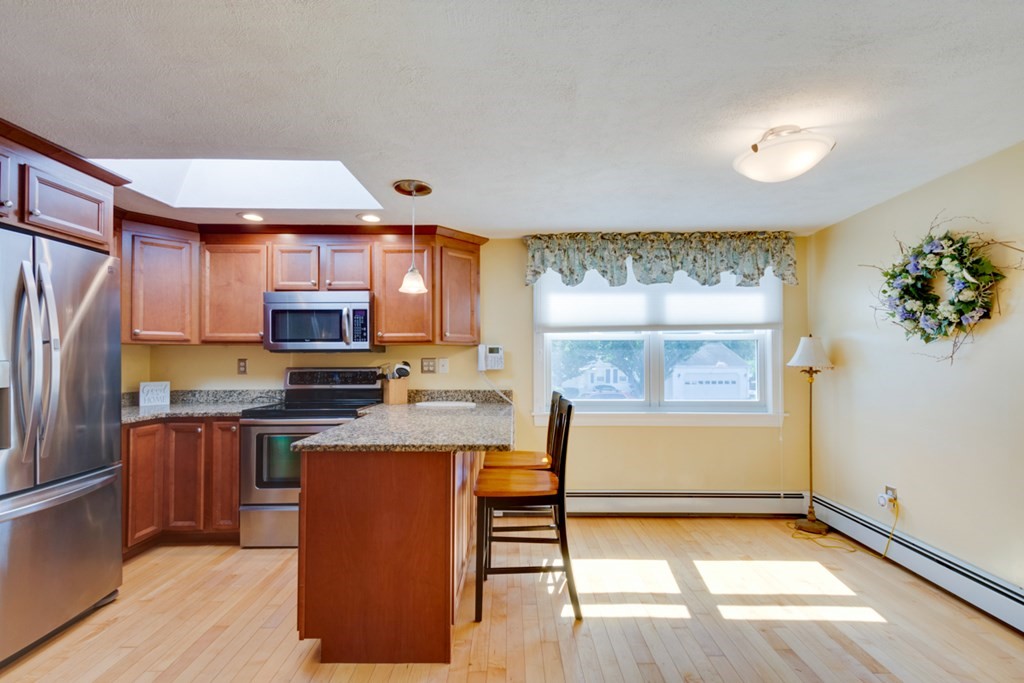 29 Anna Road Woburn, MA 01801 - Photo 5 of 29 a kitchen with stainless steel appliances granite countertop a refrigerator a sink dishwasher a stove with wooden cabinets and floor