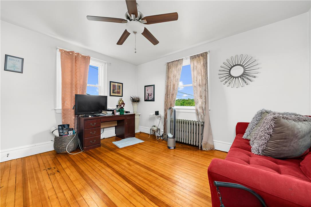 2055 Ferry Street Wilson, PA 18042 - Photo 14 of 21 This versatile room features warm hardwood flooring, bright windows, and a classic ceiling fan, creating an inviting atmosphere.
