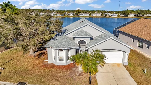 an aerial view of a house with a yard and lake view