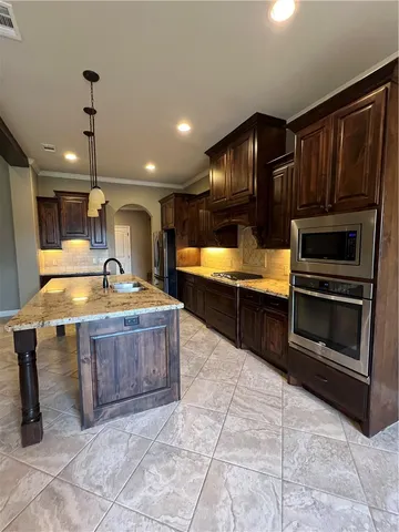 a large kitchen with kitchen island granite countertop a sink and a stove top oven