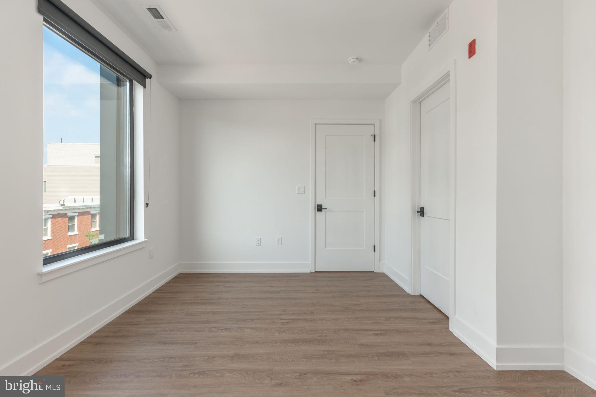 1519 Ridge Avenue, Unit 503 Philadelphia, PA 19130 - Photo 12 of 40 a view of an empty room with wooden floor and a window