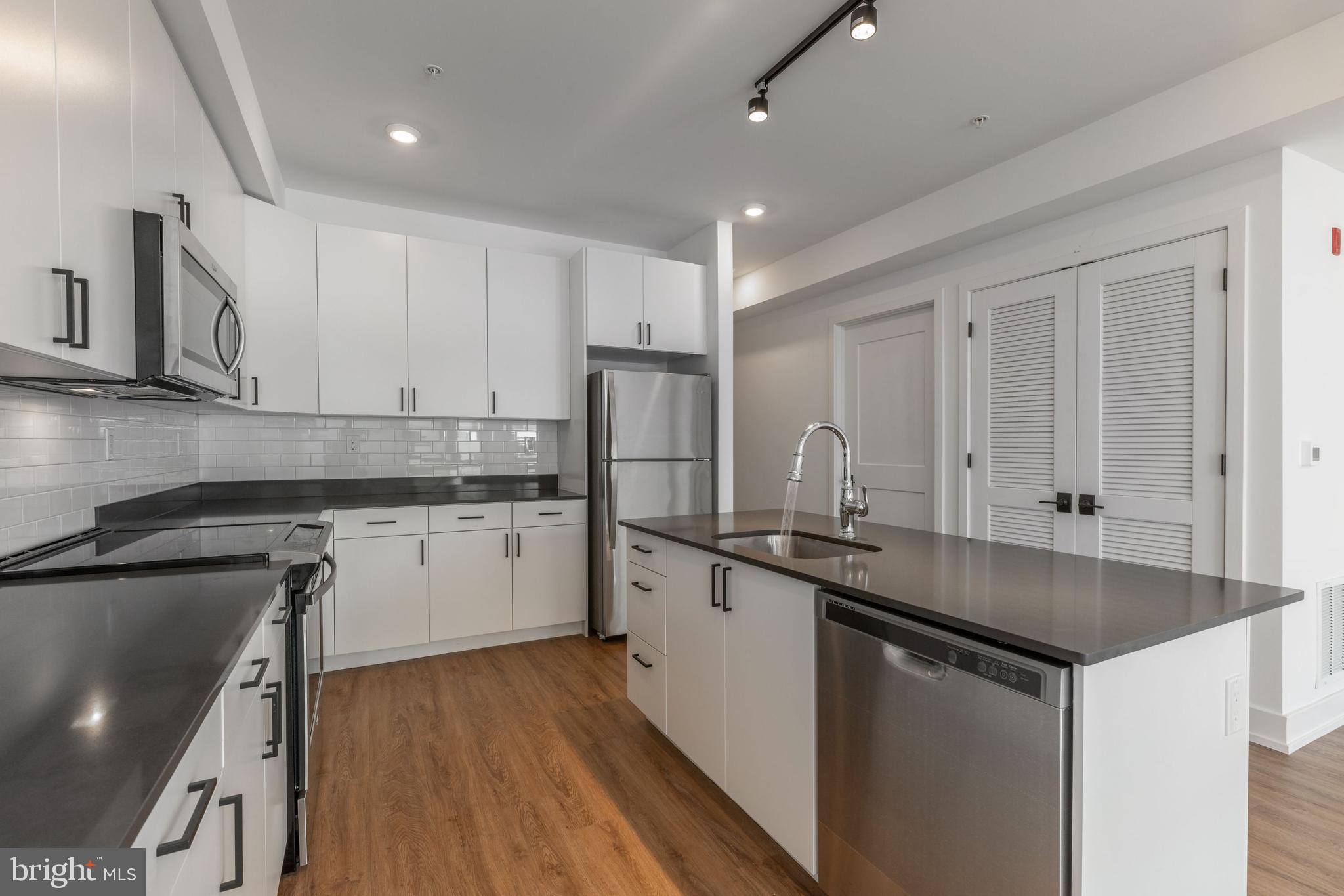 1519 Ridge Avenue, Unit 503 Philadelphia, PA 19130 - Photo 27 of 40 a kitchen with stainless steel appliances granite countertop a sink stove and refrigerator