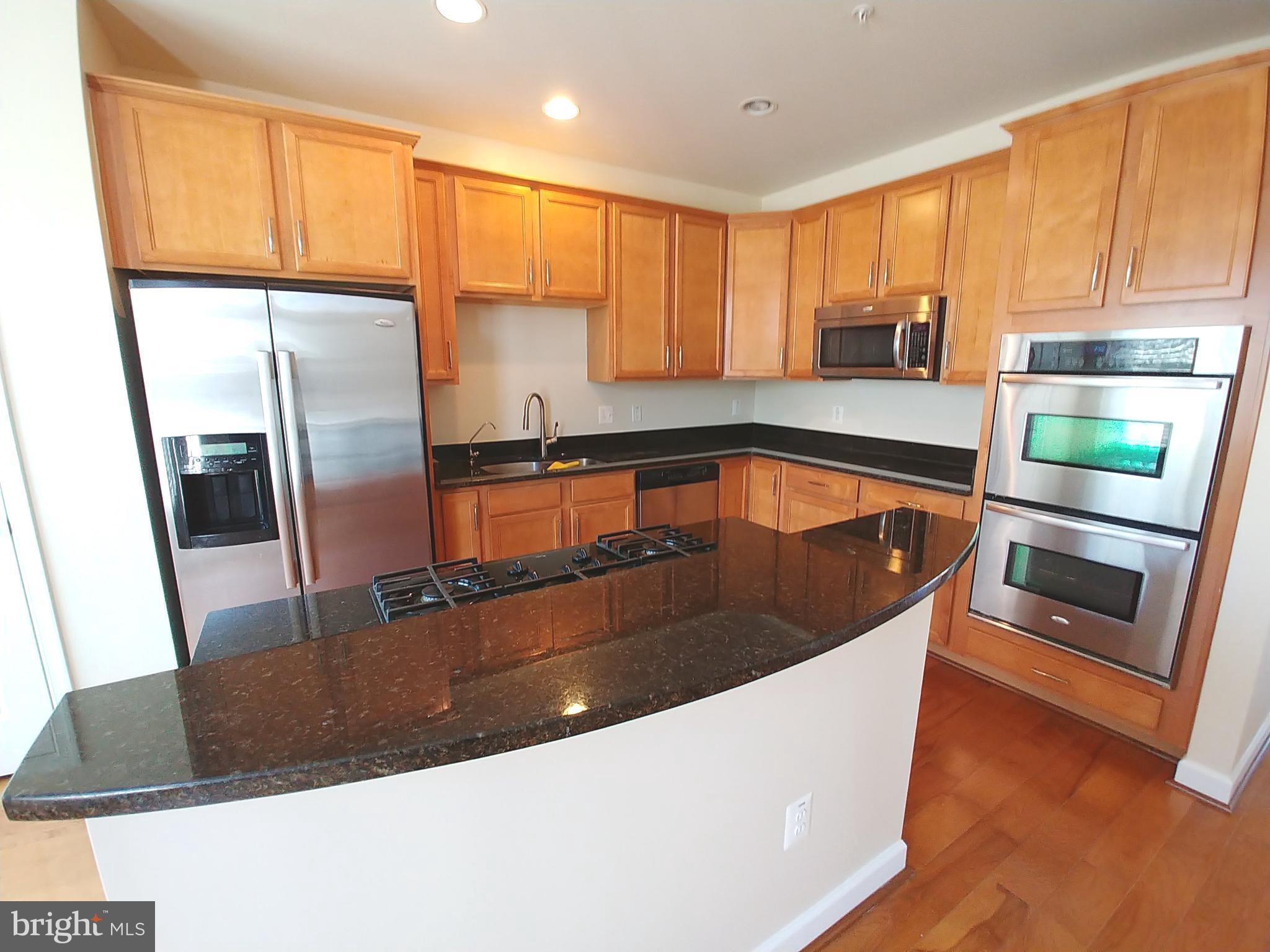 8007 Sport View Road Landover, MD 20785 - Photo 8 of 12 a kitchen with stainless steel appliances granite countertop a sink a microwave a stove and refrigerator