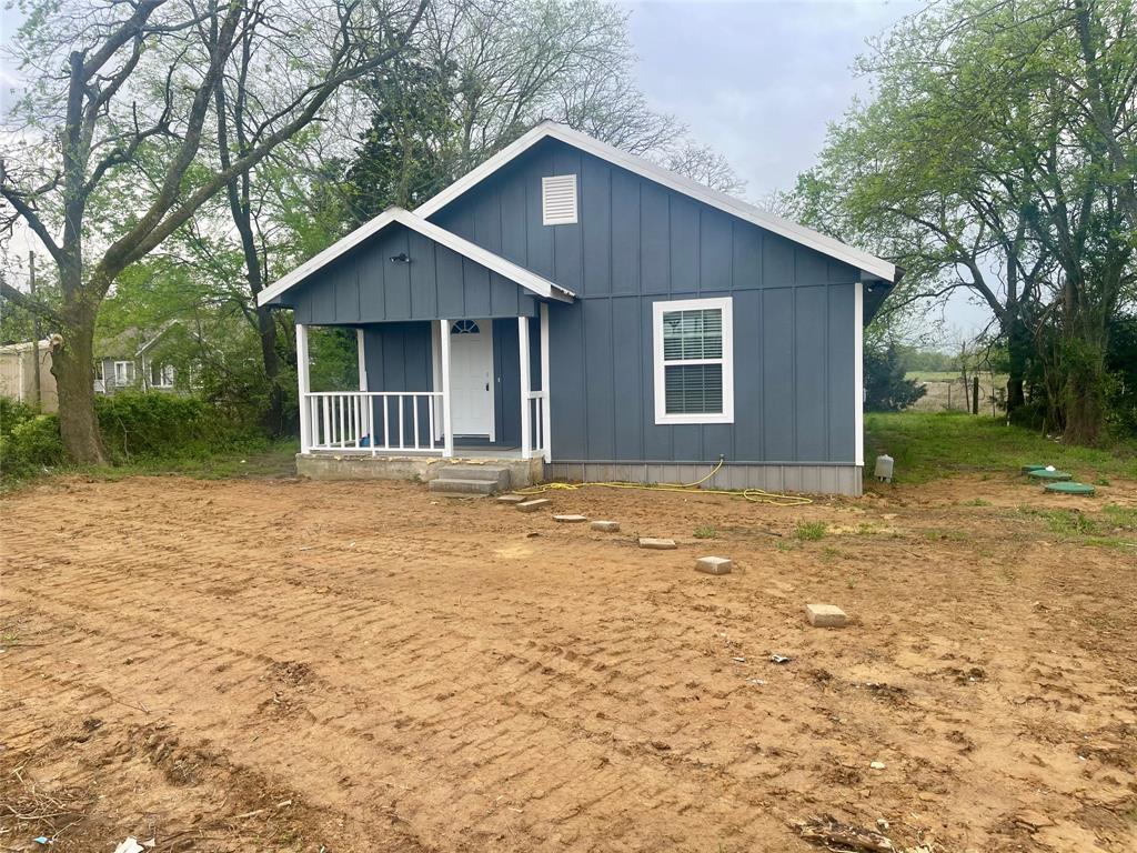 a front view of house with yard and trees around