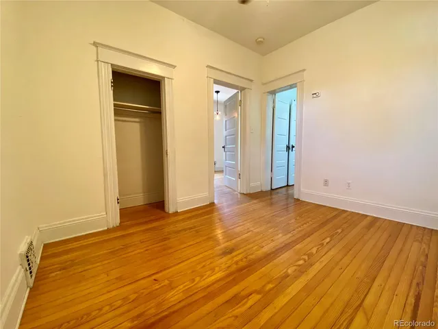 a view of empty room with wooden floor and entryway