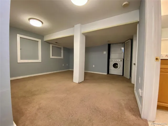 a view of an empty room with closet and a window