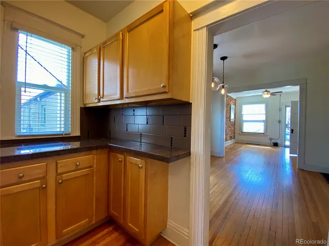 a view of a kitchen with wooden floor and a window
