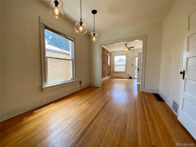 a view of a hallway with wooden floor and a chandelier