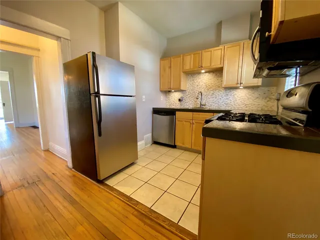 a kitchen with stainless steel appliances granite countertop a refrigerator a sink a stove and island