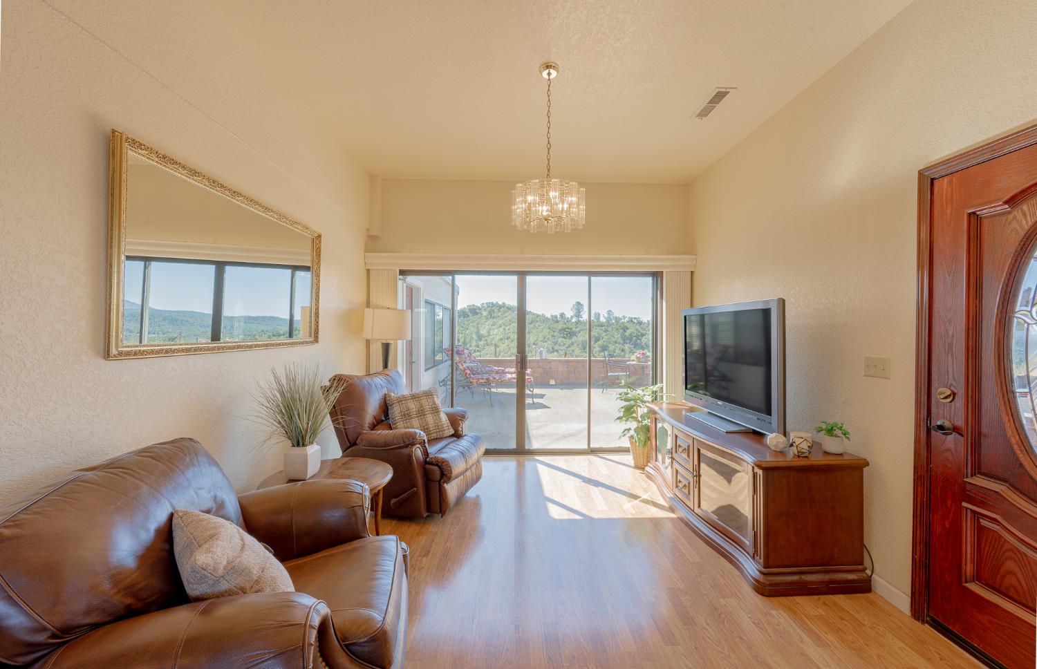5912 Old Gulch Road San Andreas, CA 95249 - Photo 6 of 71 a living room with furniture a flat screen tv and floor to ceiling window