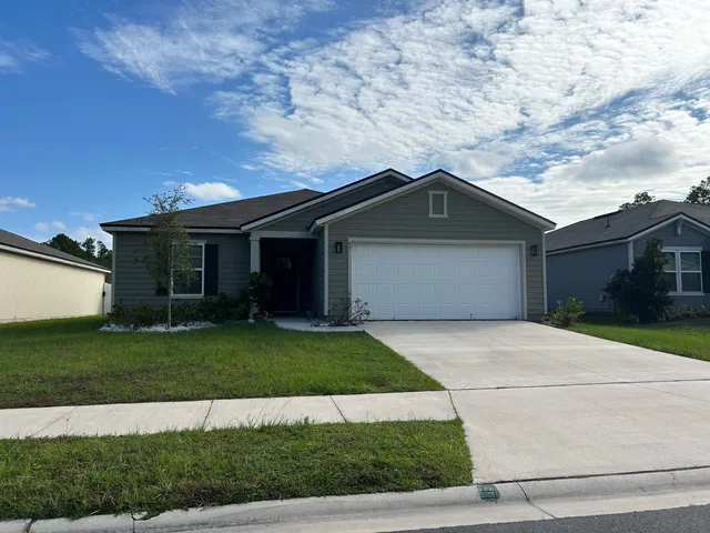a front view of a house with a yard and garage