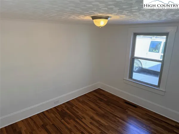 a view of a small space with wooden floor and a window