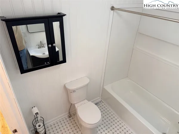 a white toilet sitting next to a bath tub