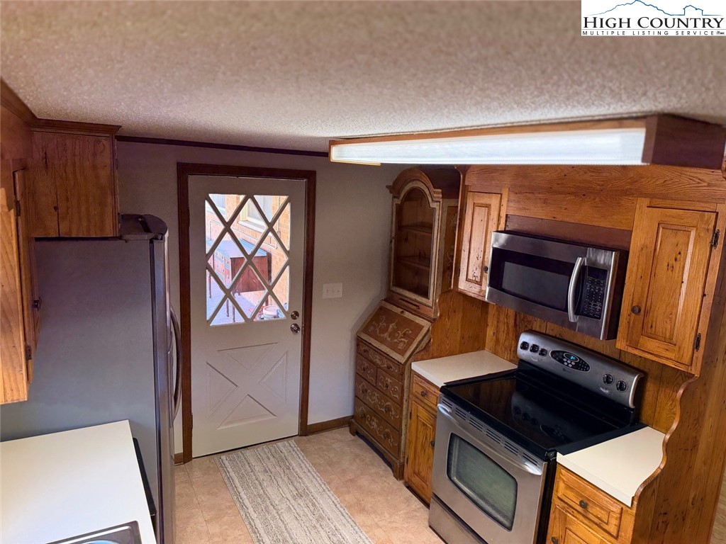 226 White Plains Road Roaring River, NC 28669 - Photo 3 of 39 a kitchen with stainless steel appliances granite countertop a stove a sink and a microwave