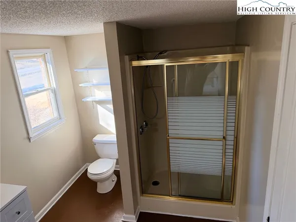 a bathroom with a toilet and a shower