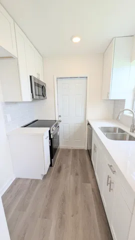 a kitchen with a sink a stove and cabinets